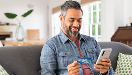 Older Hispanic man with EECU debit card and mobile phone